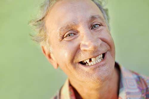 aged toothless man smiling at camera
