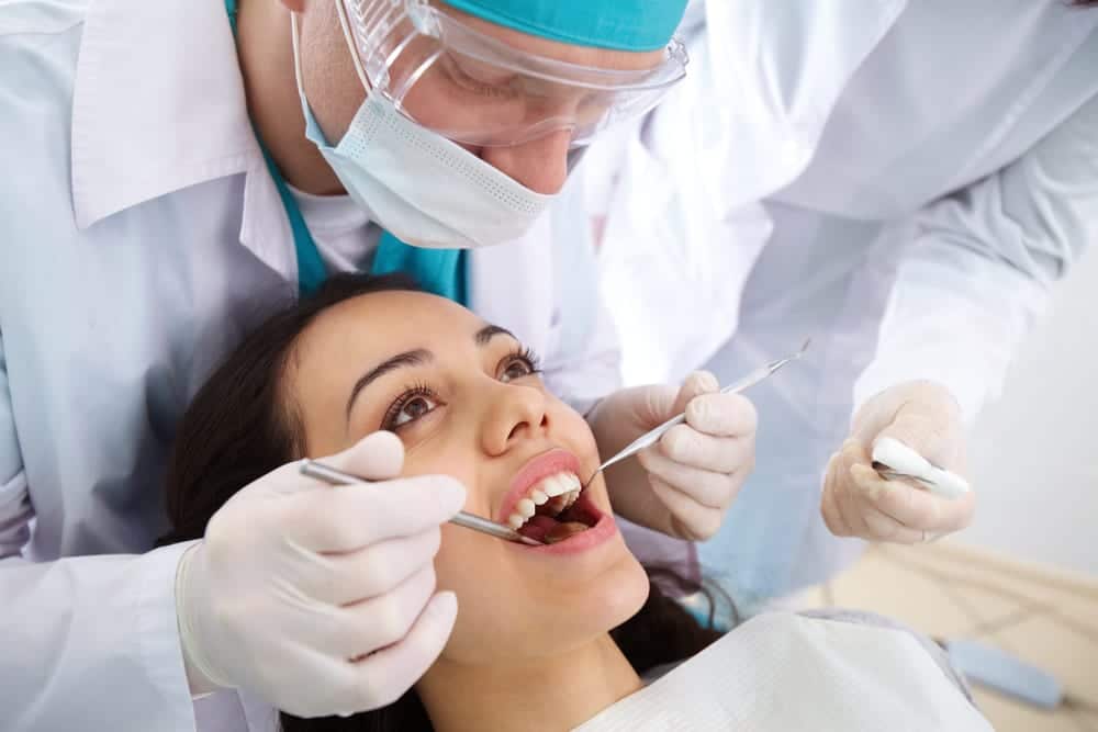 Dentist looking in mouth of female patient