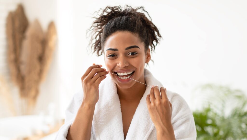 Young woman flossing at home