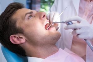 Close-up of man having mouth examined by dentist